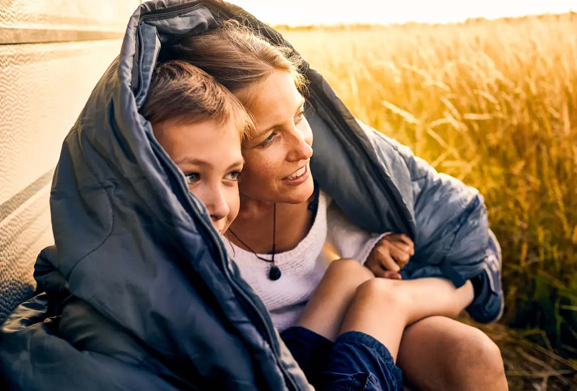 Sohn kuschelt sich mit Mutter in Jacke – bald ist Zeit für Langnese Honig.